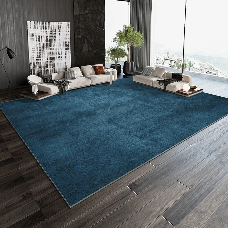 Une pièce élégante et moderne avec un canapé confortable et des éléments décoratifs soignés, sur un tapis bleu profond contrastant avec le parquet en bois.