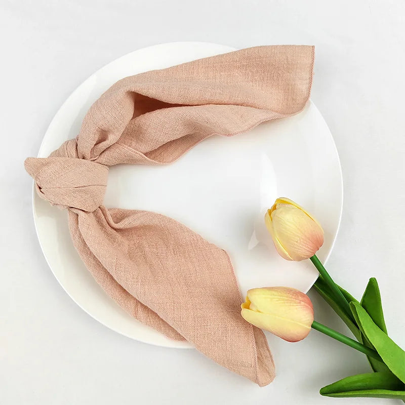 Deux tulipes jaunes posées sur une assiette blanche avec un torchon de cuisine beige plié, créant une image élégante et apaisante.