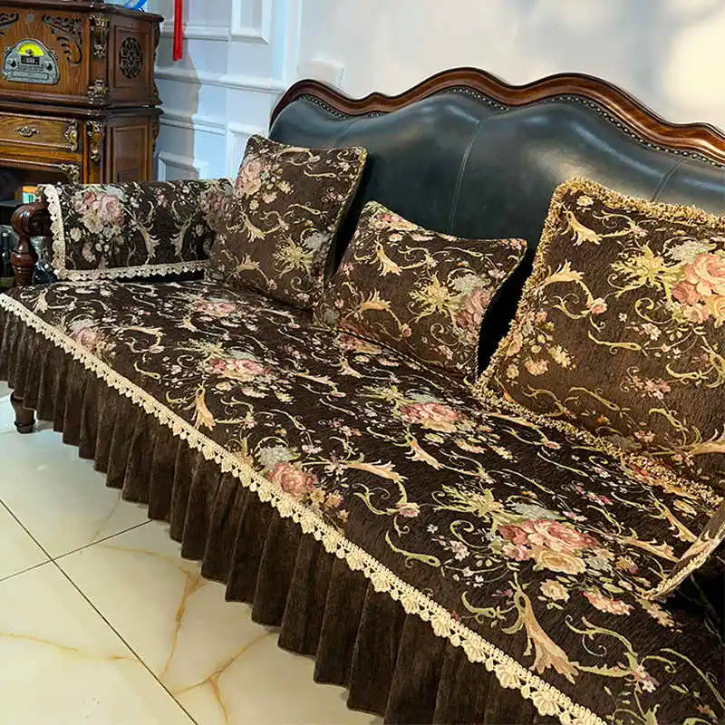 Un magnifique canapé vintage richement décoré de motifs floraux dorés et de dentelle, créant une atmosphère chaleureuse et élégante dans cette pièce.