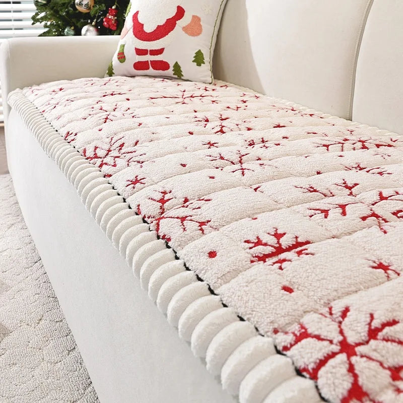 Couverture de lit cosy et festive ornée de motifs de flocons de neige rouges sur un fond beige clair, créant une ambiance chaleureuse et hivernale.