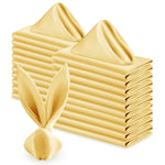 Gros plan sur un empilement de serviettes de table de couleur jaune pâle, texturées et pliées de manière artistique, créant ainsi un design graphique intéressant.