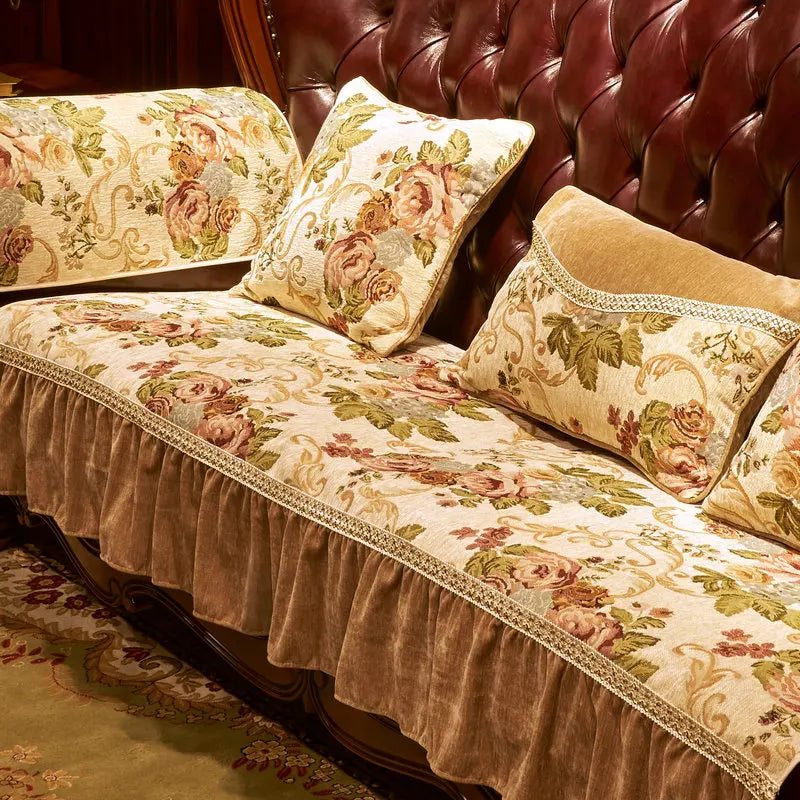 Un canapé capitonné en cuir marron foncé avec des coussins aux motifs floraux dorés et beiges, créant une ambiance chaleureuse et luxueuse.