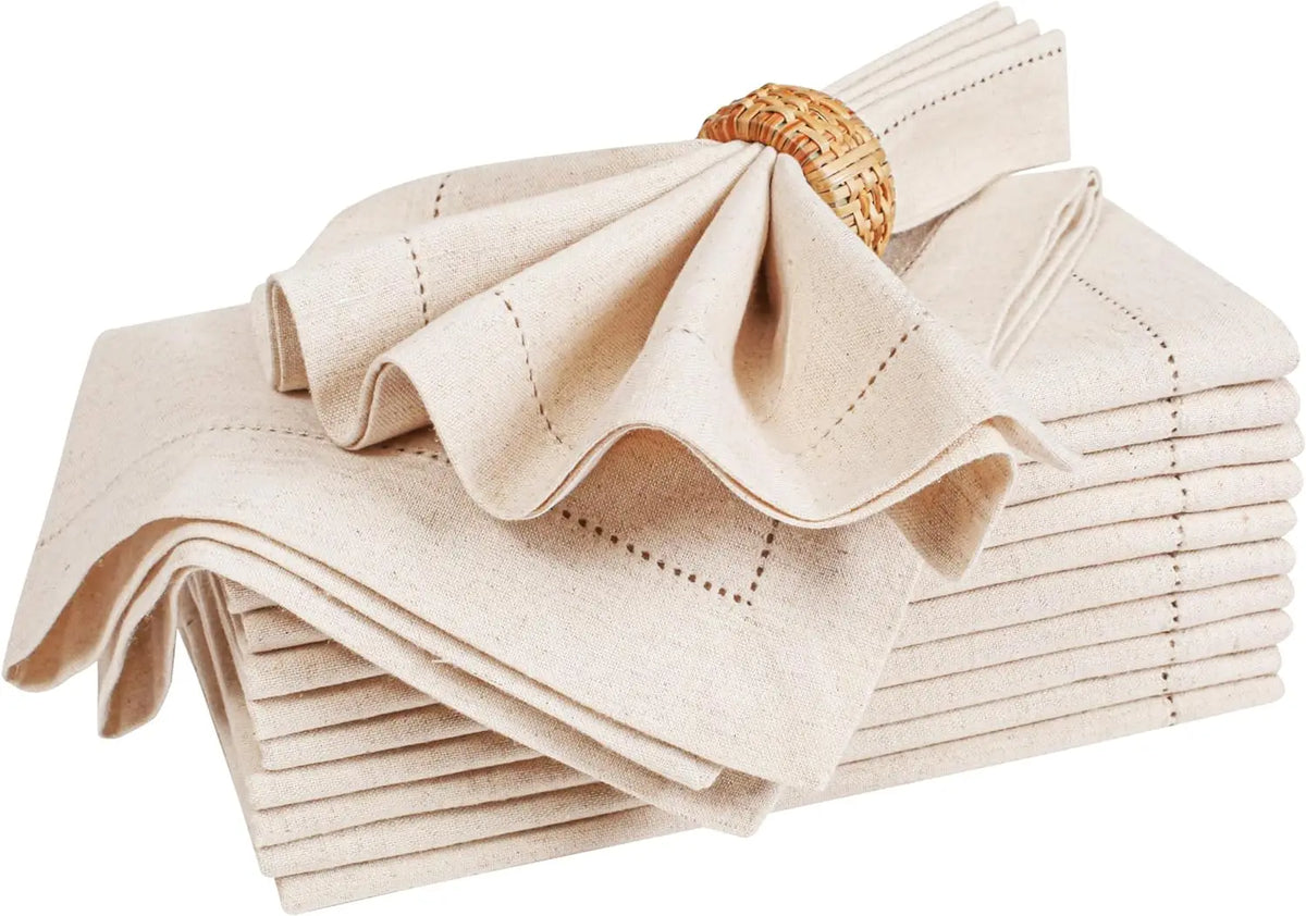 Serviettes de table en lin beige avec anneaux en rotin, avec un design chic et élégant, parfait pour une table de fête.