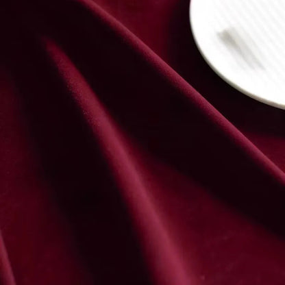 Zoom sur la texture douce et épaisse du tissu en velours bordeaux, mettant en valeur la richesse de la matière.