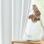 Rideau blanc élégant dans un salon moderne avec lumière naturelle. Vue de près sur une tasse de café posée sur une table en bois, créant une ambiance zen et apaisante pour la décoration intérieure. Fleurs séchées dans un vase minimaliste à côté des stores, accentuant l'esthétique chic et contemporaine de l'espace.