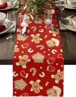 Une nappe de table rouge vif ornée de motifs de biscuits de Noël et de flocons de neige, créant une ambiance festive pour un repas de fête.