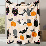 Une couverture multicolore ornée de motifs d'Halloween mignons, tels que des chats noirs, des chauves-souris, des fantômes et des citrouilles.