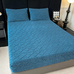 Un joli ensemble de literie bleu turquoise orné de motifs texturés, comprenant un dessus de lit et deux oreillers assortis, créant une ambiance apaisante et élégante dans la chambre.