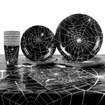 assiettes halloween araignées verres serviettes table noire blanc points brillants toile festive octobre