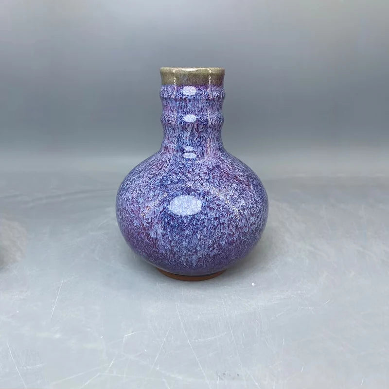 Un magnifique vase en céramique de couleur violette avec des textures et des motifs uniques, créant une pièce décorative sophistiquée et élégante.