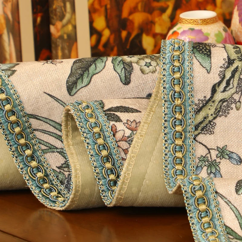 Un rouleau de tissu imprimé de motifs floraux et de bordures dorées, reflétant un style oriental riche et élégant.