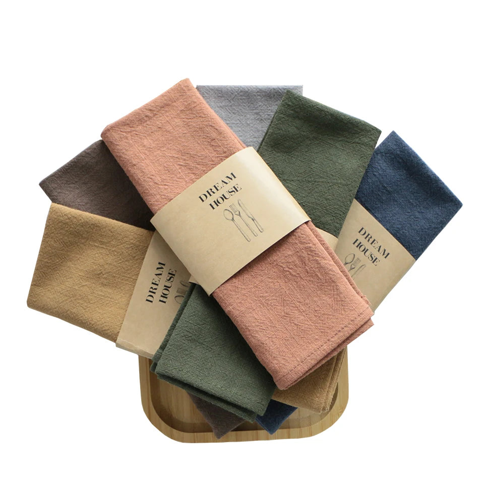 serviettes tissu pliées rustique bohème minimaliste liens anneaux couleurs beige rose vert bleu gris