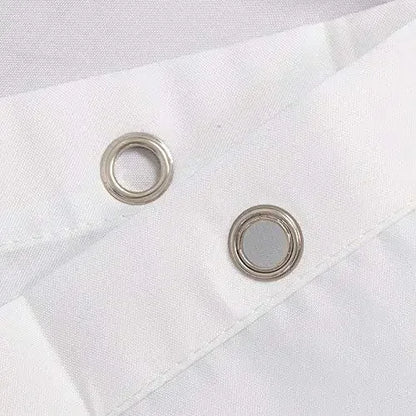 Gros plan sur les œillets métalliques du rideau, permettant une fixation aisée sur la tringle.