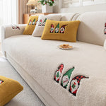 Ce canapé confortable et cocooning est orné de motifs de gnomes mignons et colorés, créant une ambiance chaleureuse et festive dans la pièce.