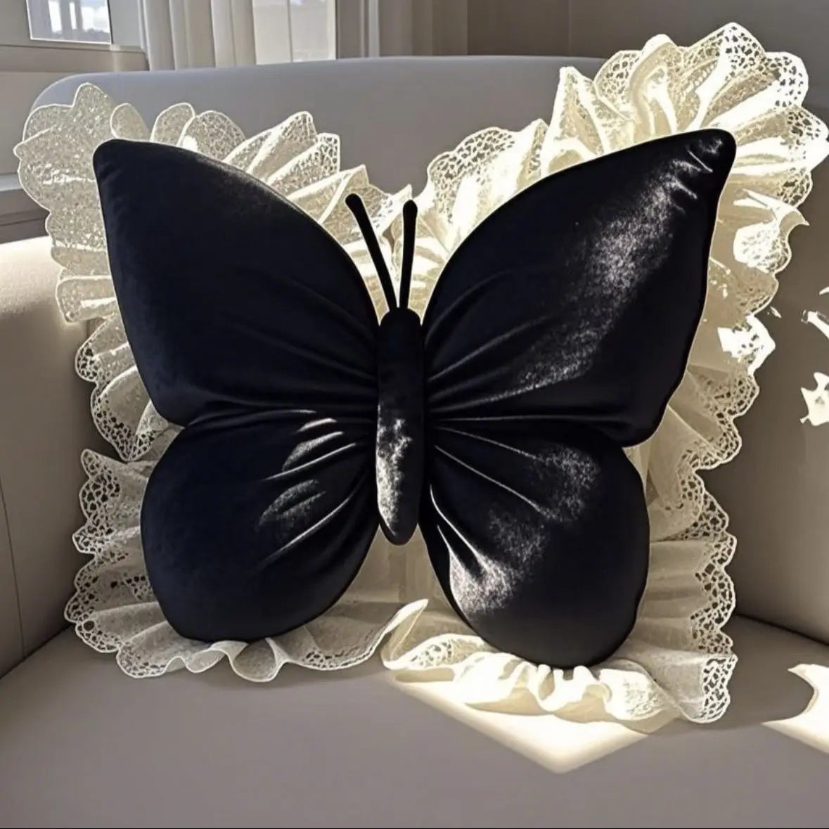 Une délicate sculpture en forme de papillon noir sur un fond de dentelle blanche apporte une touche d'élégance et de raffinement.