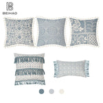 Ensemble de cinq oreillers décoratifs aux motifs floraux et géométriques dans des tons de gris et beige, avec des franges, idéal pour une décoration de style boho chic.