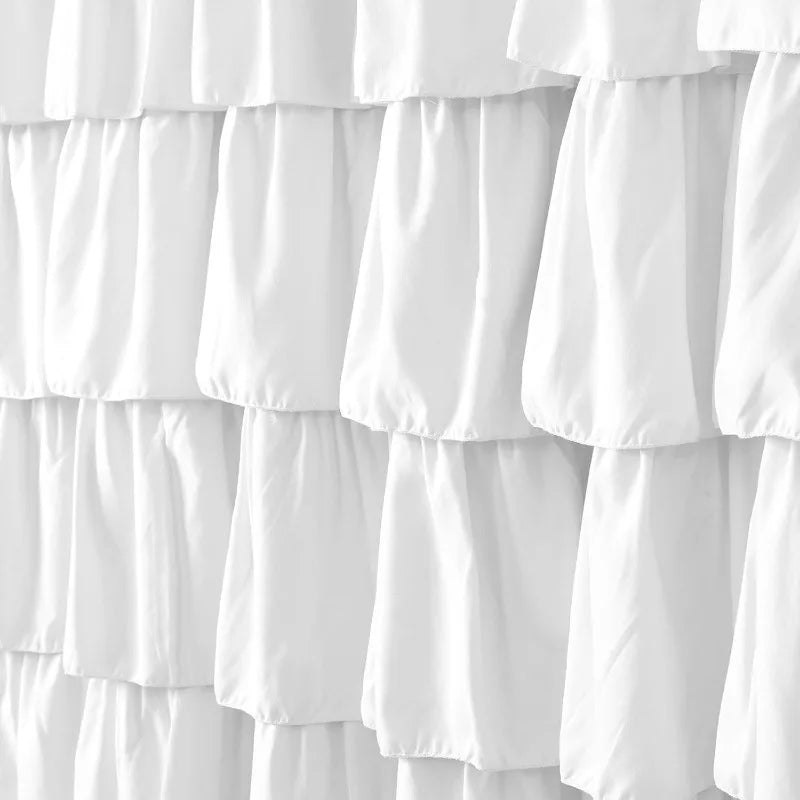 Image d'un élégant rideau à volants, en tissu de haute qualité. Le rideau est de couleur blanche, ajoutant une touche douce et apaisante à n'importe quelle pièce. Ce rideau à volants est idéal pour ajouter du style et du caractère à votre intérieur, tout en offrant une fonctionnalité essentielle de confidentialité et de contrôle de la lumière.