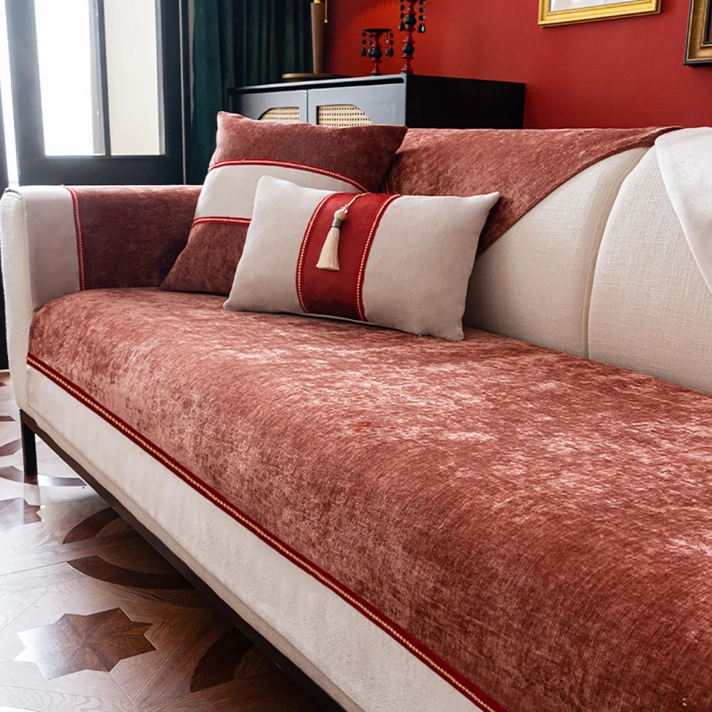 Ce sofa confortable et élégant présente un design moderne avec des coussins en tissu texturé de couleur bordeaux, rehaussés de rubans rouges qui apportent une touche raffinée à l'ensemble.