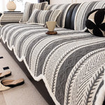 Ce motif de couverture aux rayures géométriques monochromes et texturées crée un style élégant et contemporain dans ce salon.