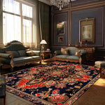 Un salon richement décoré dans un style classique avec des meubles en bois sculpté, des rideaux, un lustre en cristal et un grand tapis persan au motif floral.