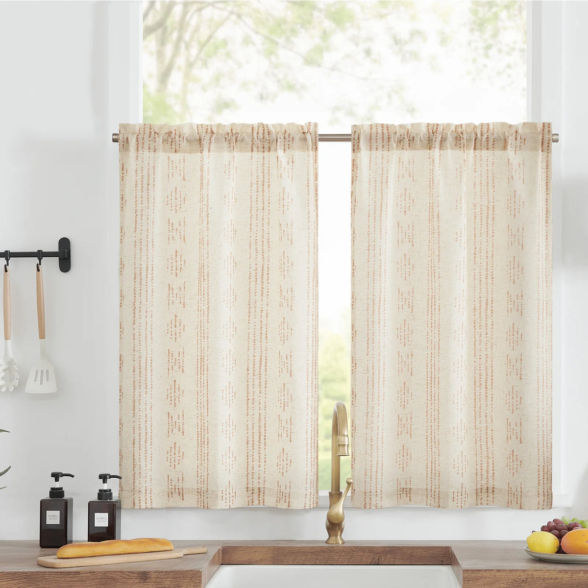 Rideaux courts beige à motifs géométriques pour cuisine, illuminent l'espace tout en préservant l'intimité. Idéals pour une ambiance chaleureuse et accueillante. Accessoires cuisine visibles pour une touche décorative.