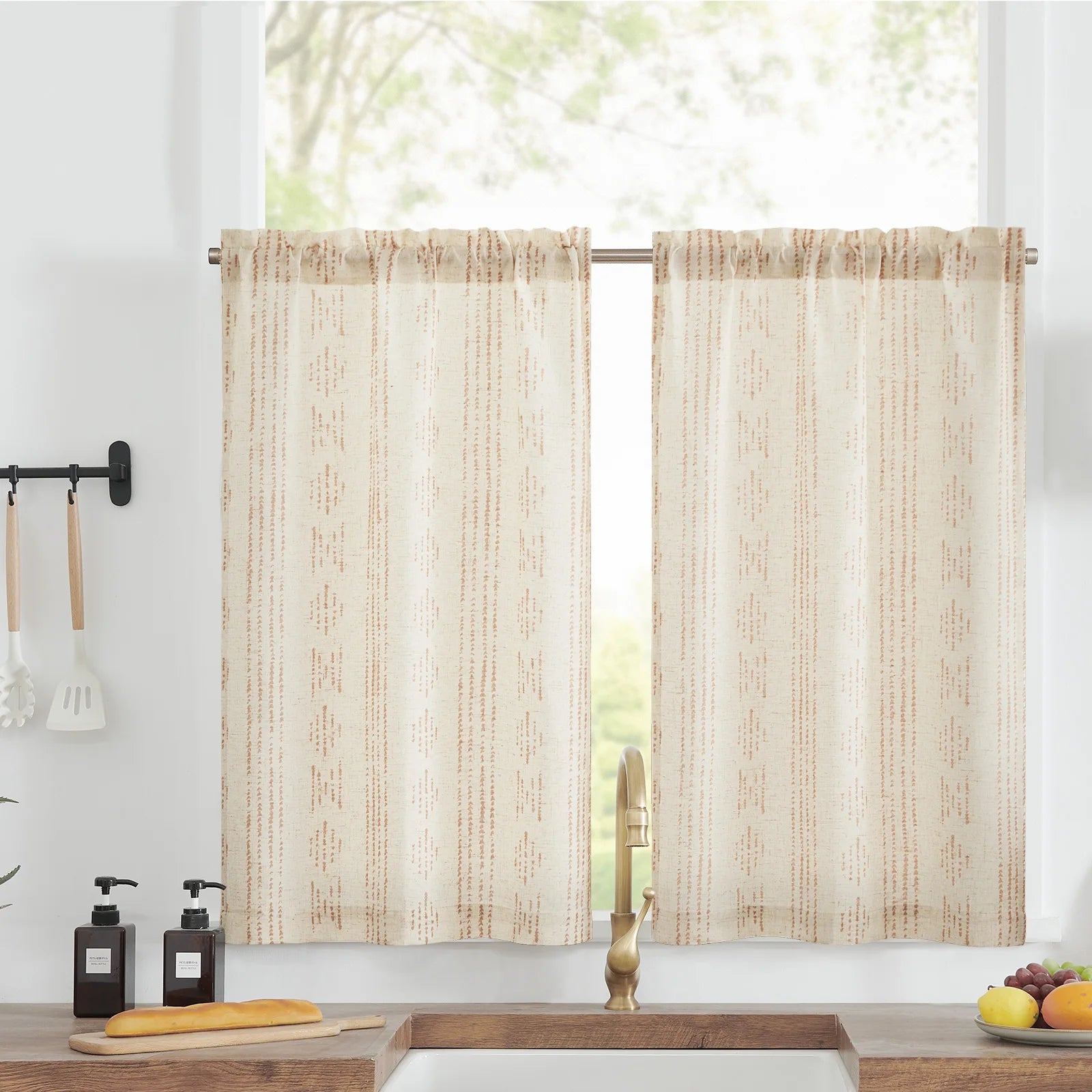 Rideaux courts beige à motifs géométriques pour cuisine, illuminent l'espace tout en préservant l'intimité. Idéals pour une ambiance chaleureuse et accueillante. Accessoires cuisine visibles pour une touche décorative.