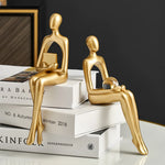 statues penseur dorées moderne décoration intérieure étagère salon lisse stylisée livre sphère verre architectural