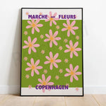 Le marché aux fleurs de Copenhague met en scène de nombreuses fleurs roses et jaunes sur un arrière-plan vert.