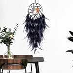 Un magnifique capteur de rêves orné de plumes noires suspendues à un cercle en métal, avec au centre une pierre aux couleurs vives, créant une atmosphère mystique et apaisante.