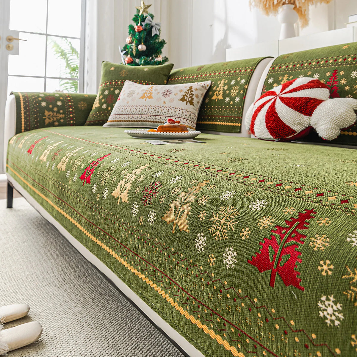 Canapé décoré de coussin à motifs de flocons de neige et d'éléments nordiques dans des tons de vert et de rouge, rappelant l'ambiance festive de Noël.