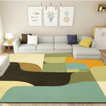 Le salon moderne est équipé d'un canapé gris avec des coussins de couleurs variées, des cadres décoratifs muraux et un tapis aux motifs abstraits chauds et colorés.