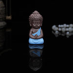 statuette bouddha artisanale couleur noir orange jaune bleu texture granulée méditatif argile violette