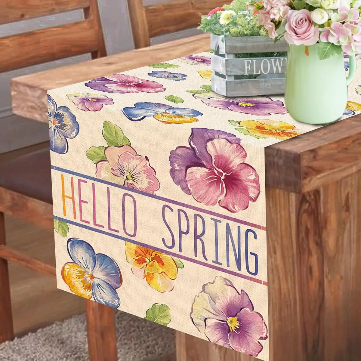 Ce chemin de table délicat et printanier avec ses fleurs colorées comme des pensées violettes et jaunes transmet une ambiance chaleureuse et printanière, parfaite pour accueillir la nouvelle saison.