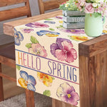 Ce chemin de table délicat et printanier avec ses fleurs colorées comme des pensées violettes et jaunes transmet une ambiance chaleureuse et printanière, parfaite pour accueillir la nouvelle saison.