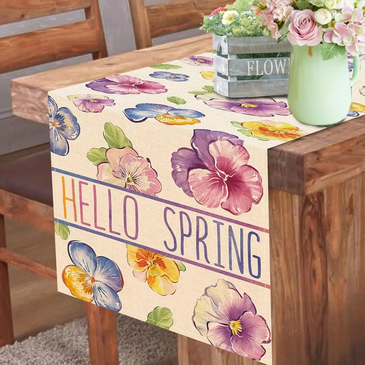 Ce chemin de table délicat et printanier avec ses fleurs colorées comme des pensées violettes et jaunes transmet une ambiance chaleureuse et printanière, parfaite pour accueillir la nouvelle saison.