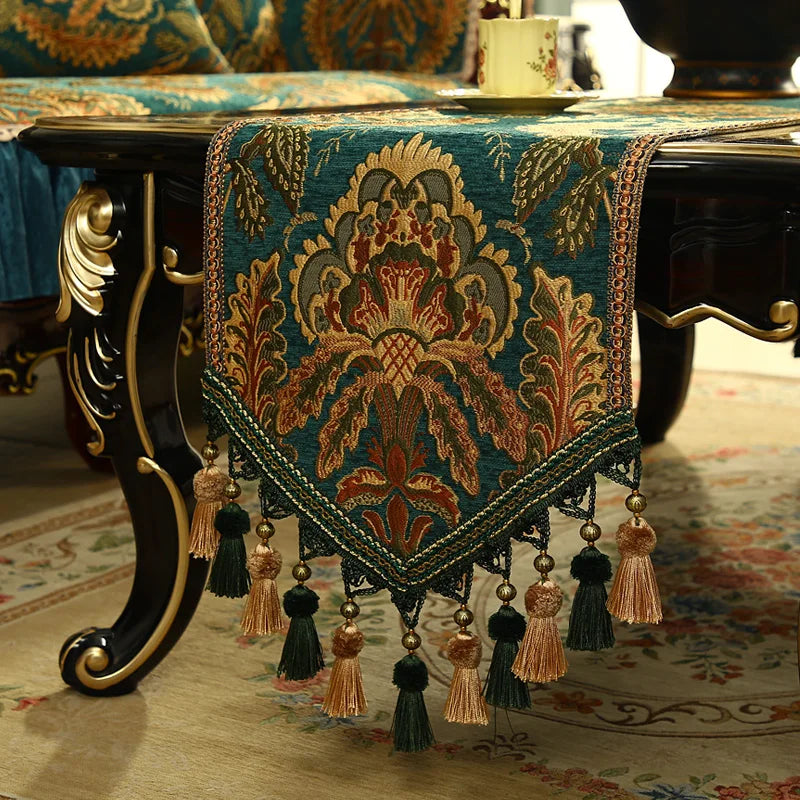 Magnifique nappe de table brodée de motifs floraux et végétaux ornés de perles et de glands décoratifs.