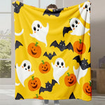 Une couverture jaune motif Halloween avec des fantômes, des chauves-souris et des citrouilles aux couleurs vives.