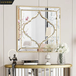 Miroir décoratif doré avec motif floral et étagère en métal pour le décor de la maison.