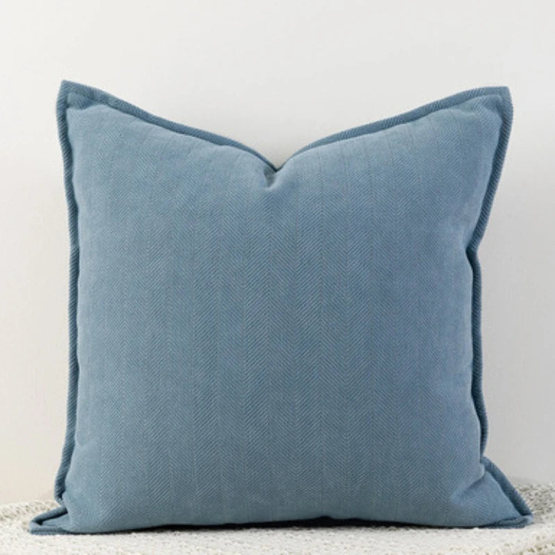 Coussin décoratif bleu gris texturé avec un motif en chevrons, parfait pour apporter une touche de sophistication à votre décor d'intérieur.