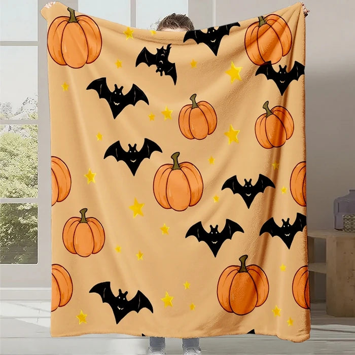 Une couverture fleece décorative avec des motifs de citrouilles et de chauves-souris sur un fond jaune clair, évoquant une ambiance festive d'Halloween.