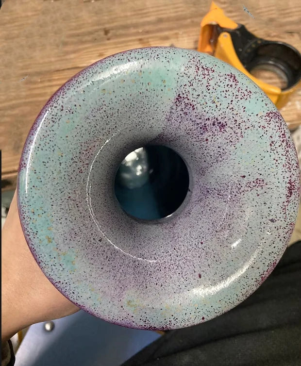 Un bol en céramique décoratif avec un motif coloré et un creux central, offrant une composition intéressante et une texture unique.