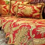 Ensemble de coussins décoratifs rouges et dorés avec des motifs floraux élégants.