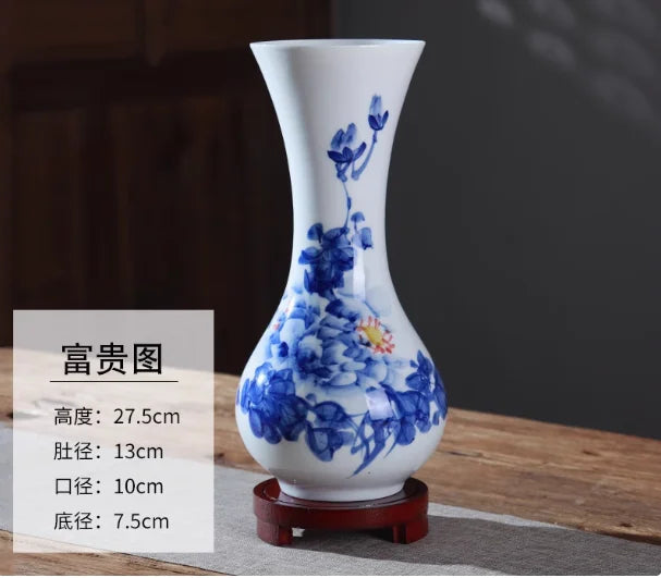 Vase de porcelaine blanche décoré de fleurs bleues sur un support en bois.