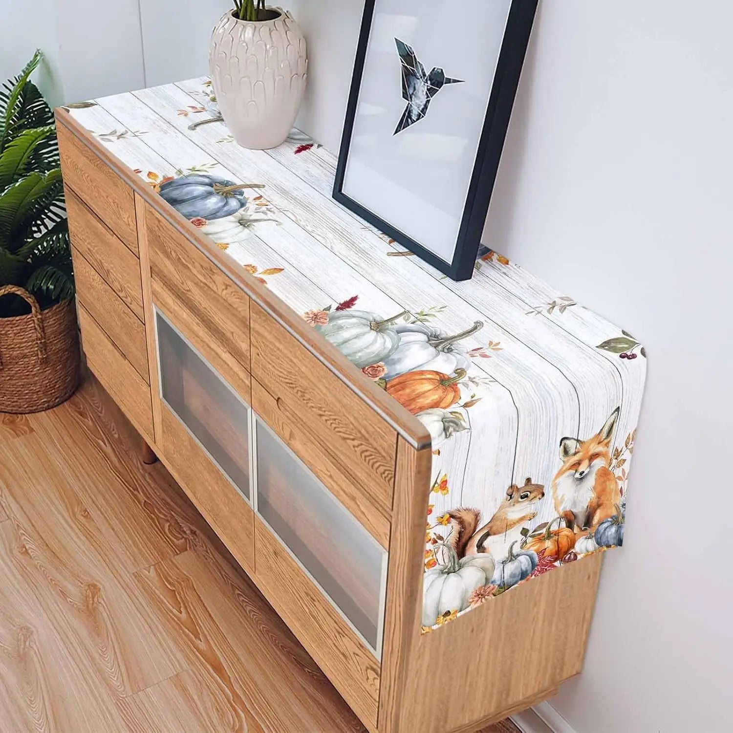 L'image montre un meuble de rangement en bois avec un joli motif automnale représentant des citrouilles, des animaux et des feuilles.