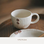 Une tasse blanche élégante et une assiette assortie posées sur une surface en bois sombre, offrant un look raffiné et minimaliste.