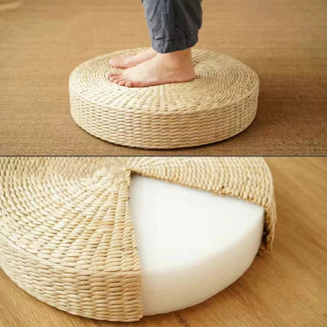 Pouf rond en paille placé près d'une fenêtre avec plantes vertes