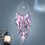 Magnifique attrape-rêves rose et gris suspendu devant une lune brillante et une lanterne, créant une atmosphère féerique et apaisante.