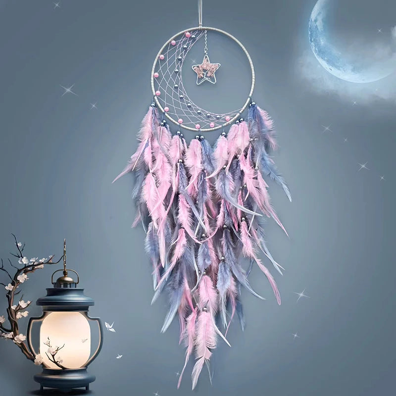 Magnifique attrape-rêves rose et gris suspendu devant une lune brillante et une lanterne, créant une atmosphère féerique et apaisante.