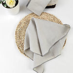 Une nappe de table en fibre de papier tressée, accompagnée d'un pot de fleurs et d'un tissu gris.