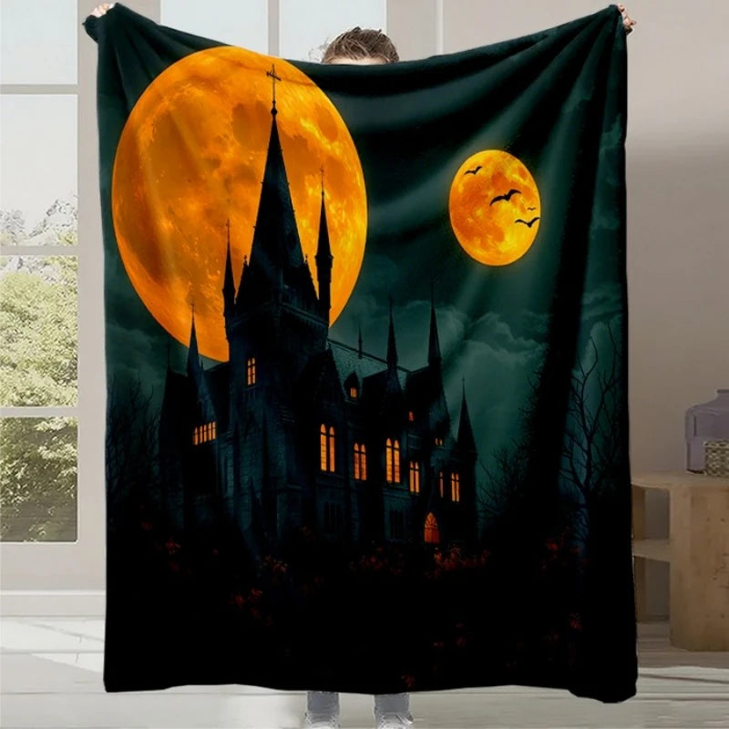 Couverture chaude représentant un château médiéval dans la nuit avec un croissant de lune et des lunes oranges éclatantes dans le ciel sombre.